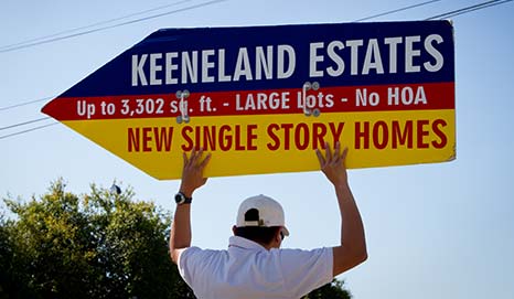 guy holding directional sign